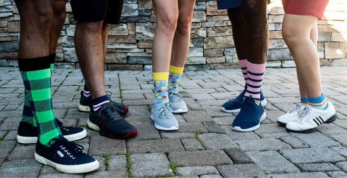 five people showing off their coloful sock styles
